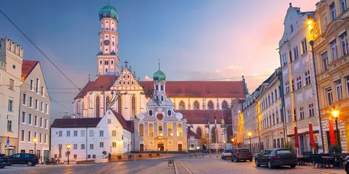 Blick auf die Altstadt von Augsburg über einen Platz hinweg, im Hintergrund eine Kirche