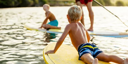 Kinder auf Stand Up Paddles im See